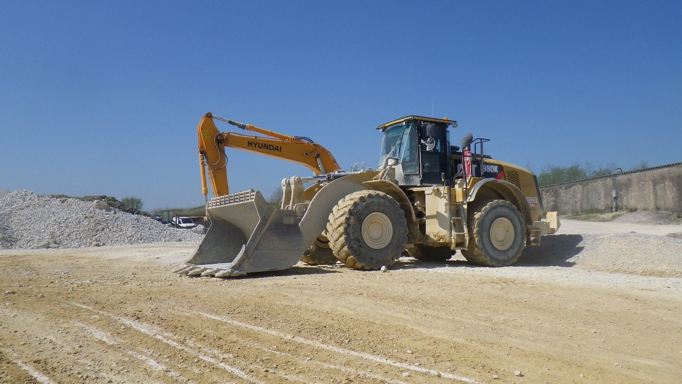 Yellow CAT front end loader parked next to an Hyundai excavator