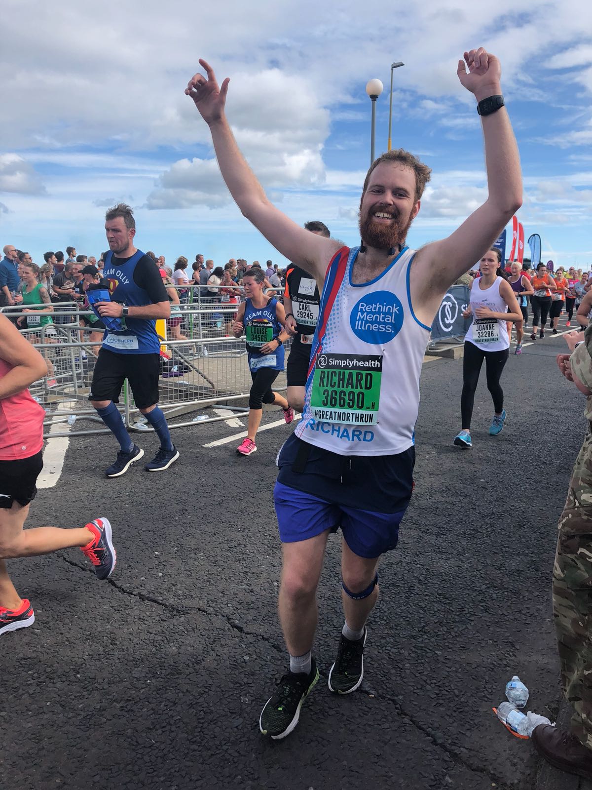 A man running a marathon with arms in the air