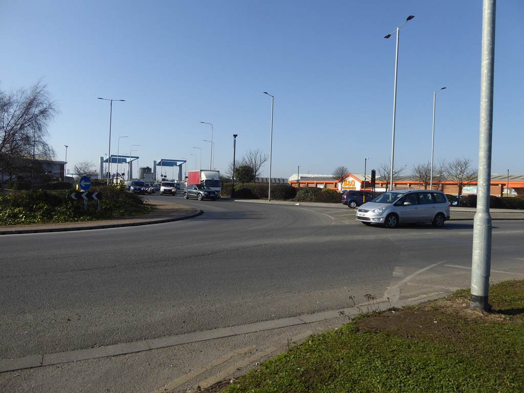 Silver family car approaching an empty roundabout